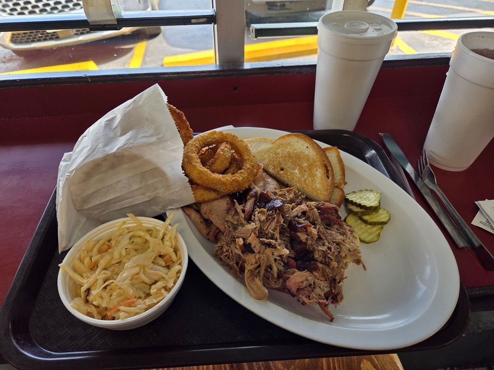 Two meat plate with onion rings and slaw.